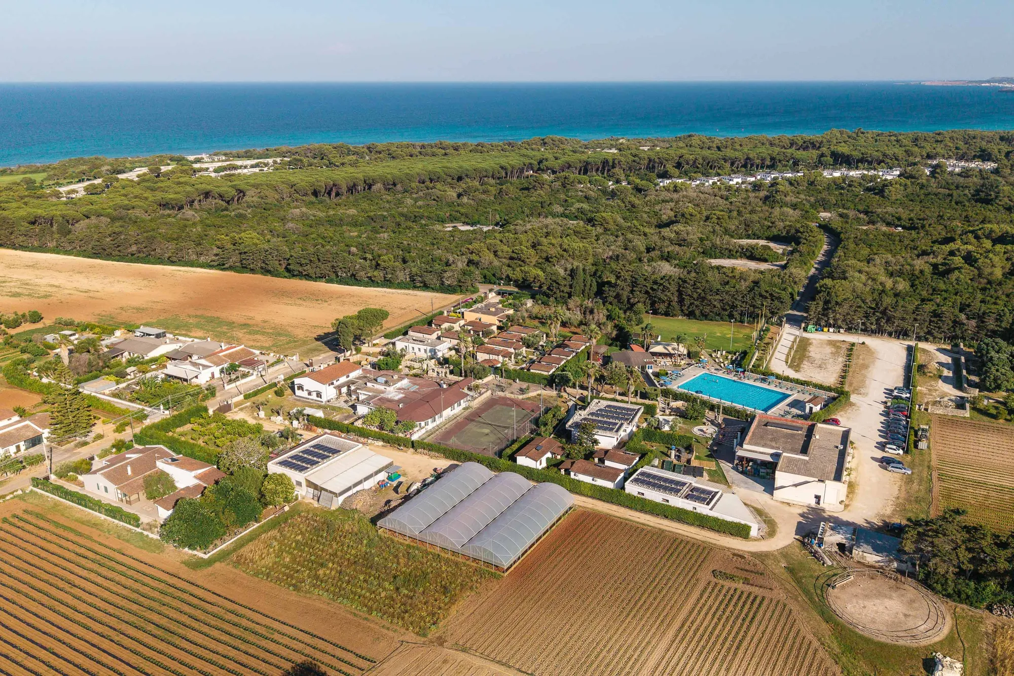 L'agriturismo visto dall'alto, tra i campi, con il mare all'orizzonte