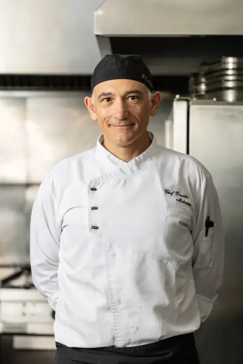Lo chef in giacca bianca nella cucina del ristorante