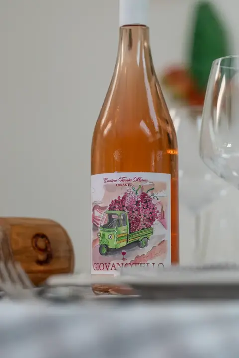 Una bottiglia di rosato della Tenuta Merico sul tavolo apparecchiato