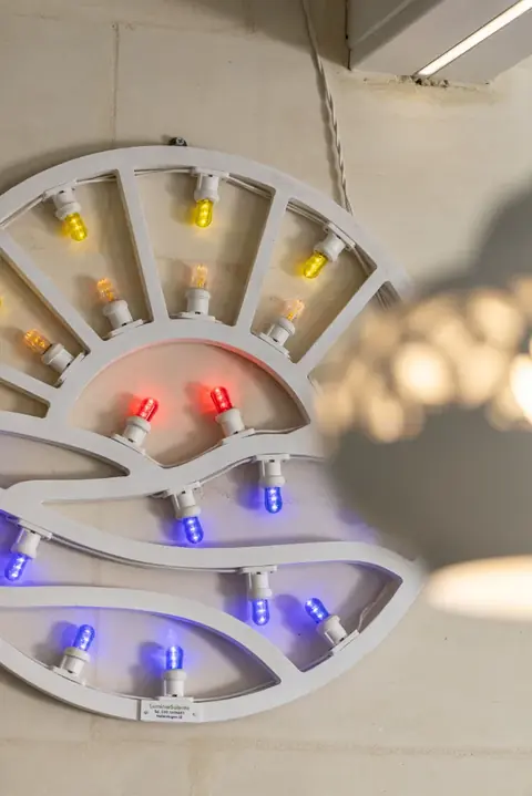 Un'installazione di lampadine colorate sulla parete della sala